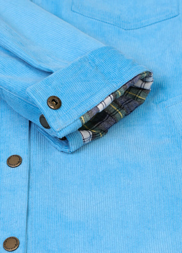 Close-up of the rolled cuffs on a women's blue flannel-lined corduroy shacket