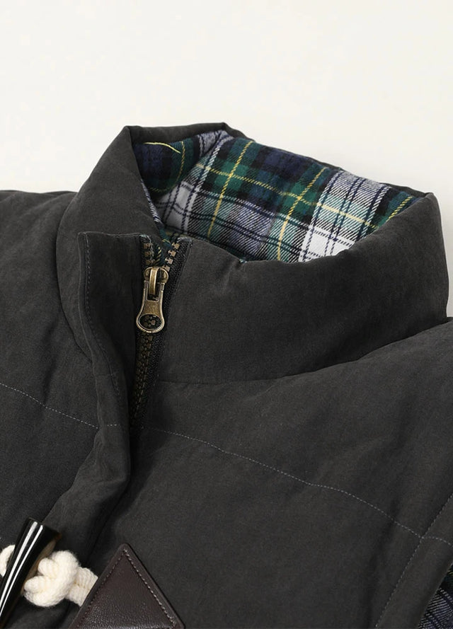 Close-up of the womens collar of a black puffer vest with flannel lining