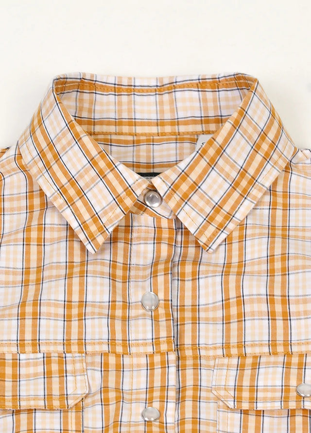 Close-up of women's chest pocket pearl snap orange white plaid vest collar