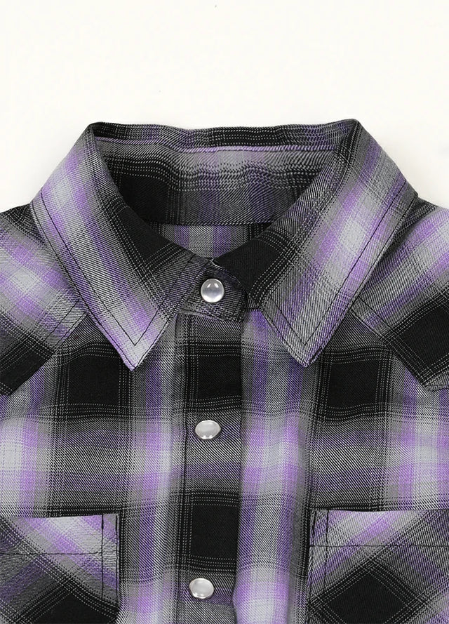 Close-up of women's chest pocket pearl snap purple black plaid vest collar