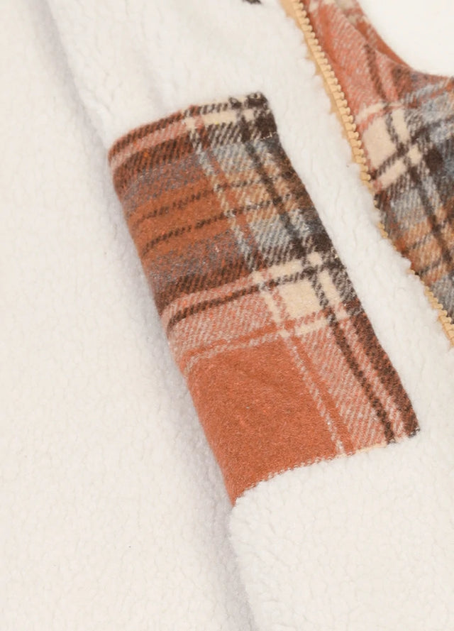 Close-up of women's orange full zip sherpa lined plaid vest inner pocket