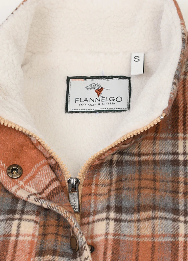 Close-up of women's orange sherpa lined zip up plaid vest collar