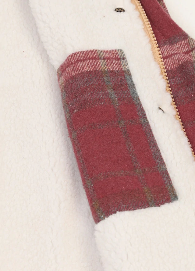 Close-up of women's purple zip-up sherpa-lined plaid vest inner pocket