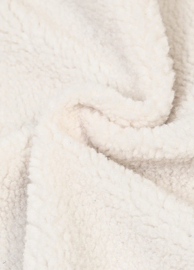 Detailed close-up of sherpa lined on the womens warm purple plaid vest fabric