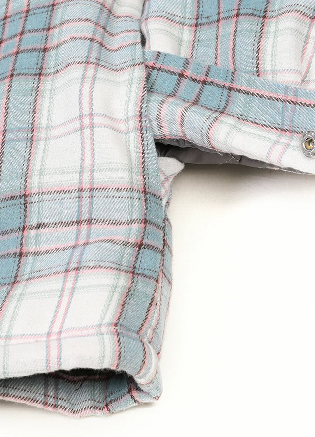 Close-up of women's white and blue warm quilted-lined plaid jacket chest pocket