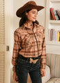 Women in a pink pearl snap western flannel plaid shirt