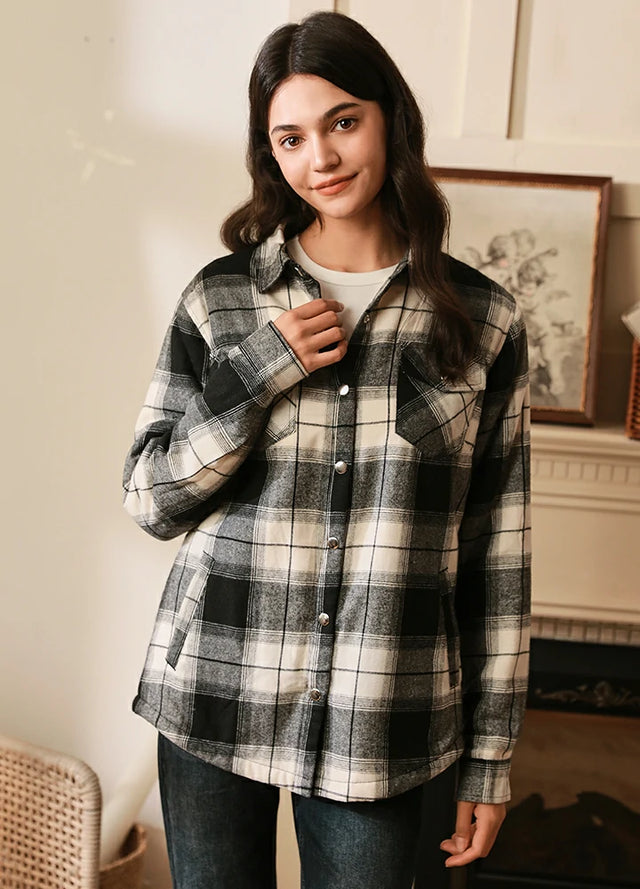 Women in a sherpa-lined white black plaid flannel jacket