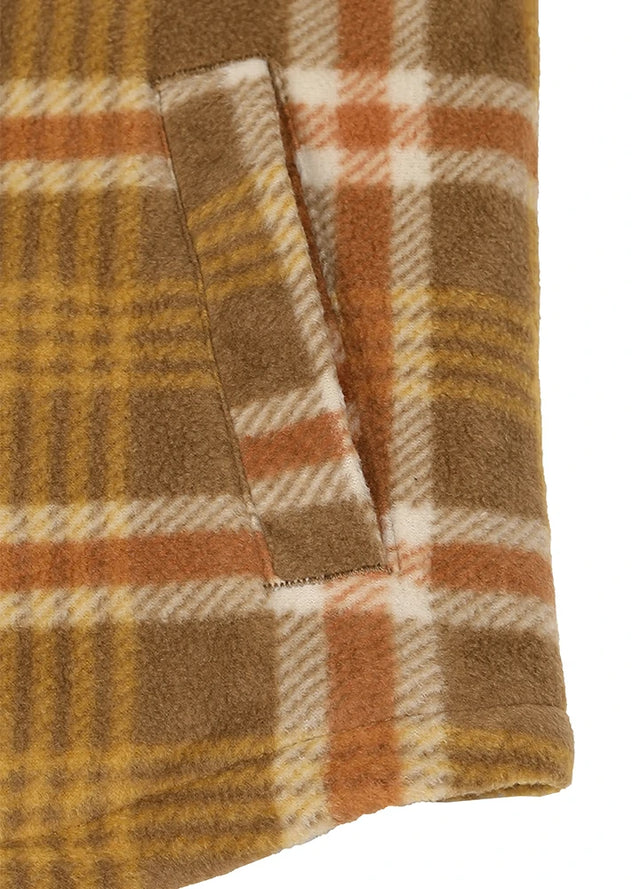 Close-up of a plaid fleece blanket or throw in warm brown, mustard yellow, orange, and cream colors, showing a fold-over section with a stitched edge.