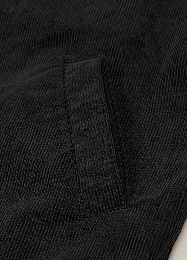 Zoomed-in view of the hand pocket on a women's black corduroy jacket