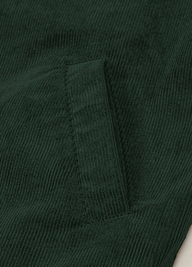 Zoomed-in view of the hand pocket on a women's dark green corduroy jacket