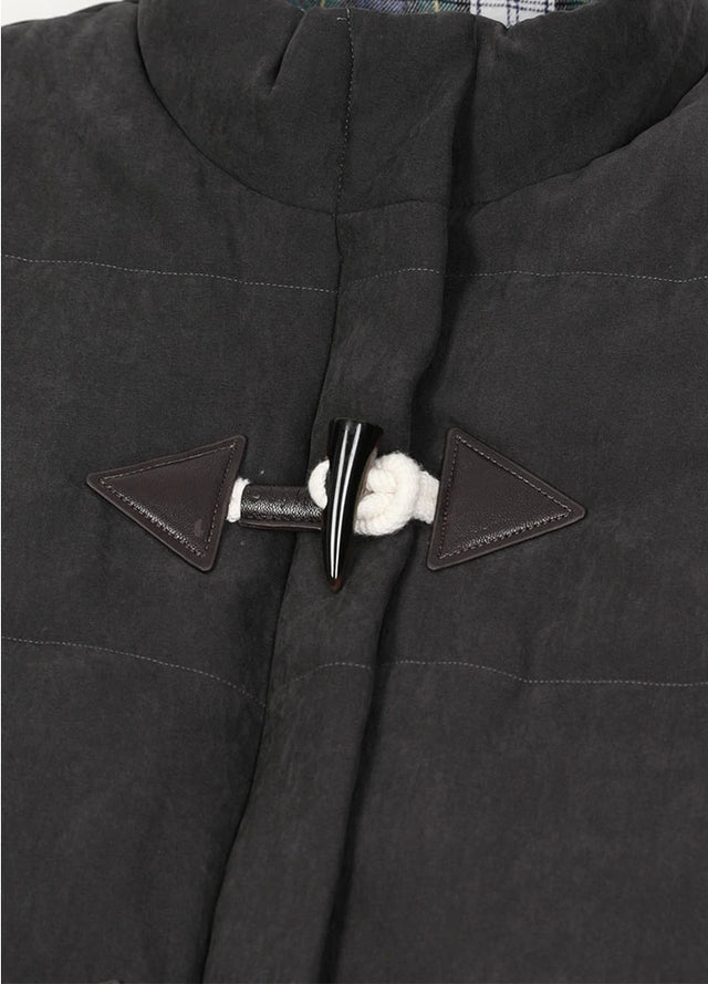 Zoomed-in view of the horn toggle on a womens black puffer vest