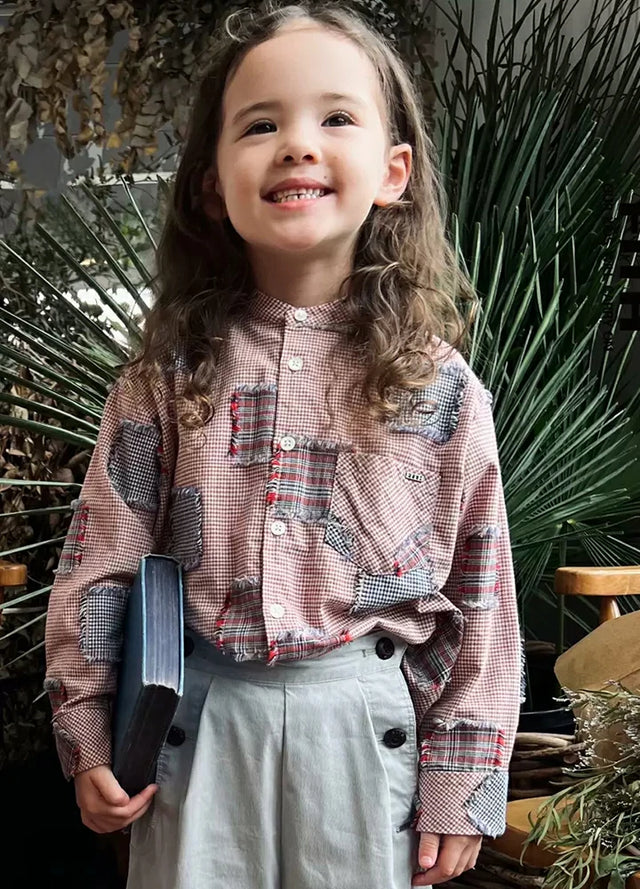 A smiling girl in pink toddler plaid patchwork long sleeve flannel shirt