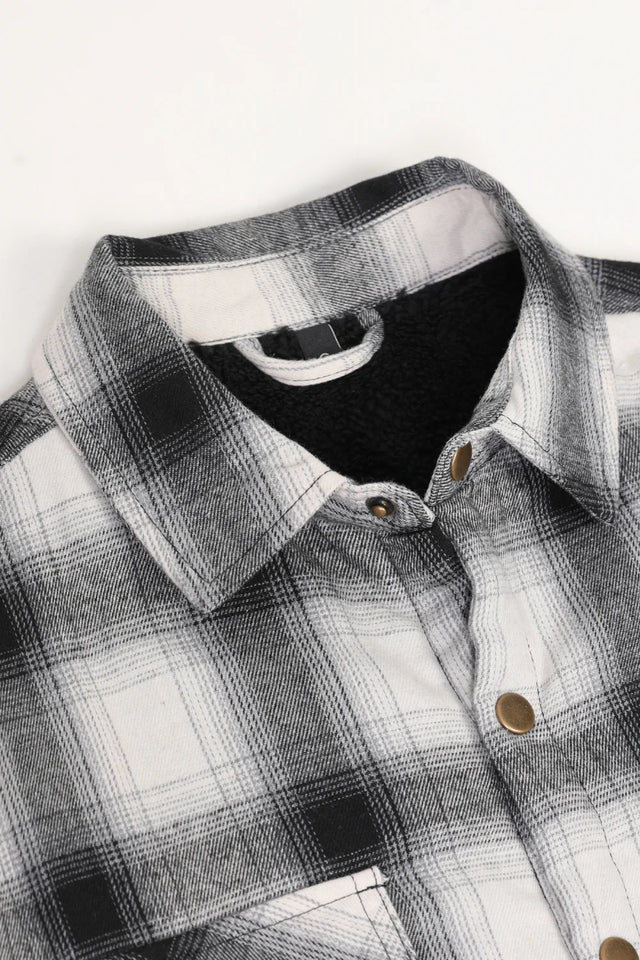 Close up of the lapel of white and black men's sherpa lined flannel plaid jacket