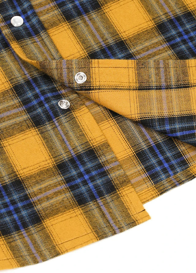Close-up of the snap button of yellow blue men's pearl snap plaid long sleeve western shirt