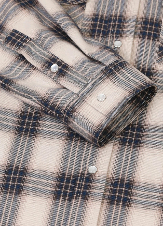 Close-up of the cuff of beige gray men's plaid outdoor long sleeve western shirt