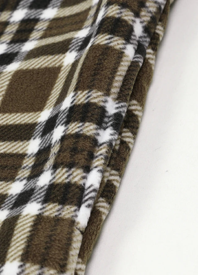 Close-up of the seam pocket of brown white men's sherpa lined plaid shirt jacket with button closure