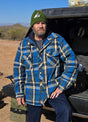 Front view of a man in a blue khaki men's quilted plaid flannel hoodie leaning against the rear of a car