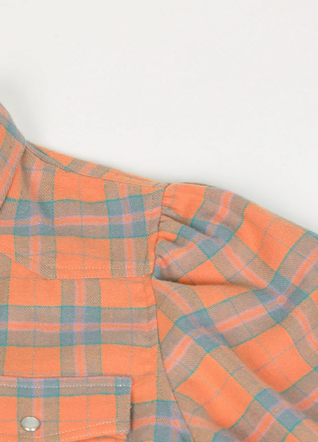 Close-up of the fabric on a women's orange plaid cotton shirt dress