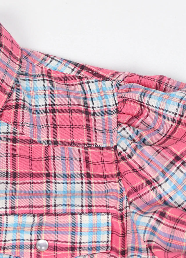 Close-up of the fabric on a women's pink plaid cotton shirt dress