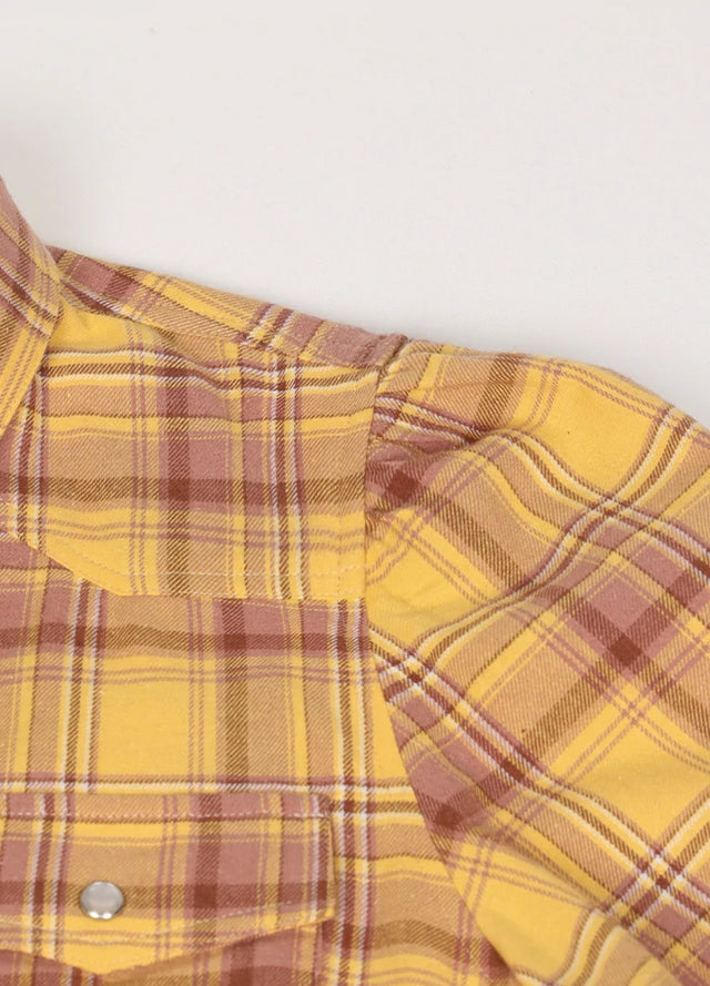 Close-up of the fabric on a women's yellow plaid cotton shirt dress