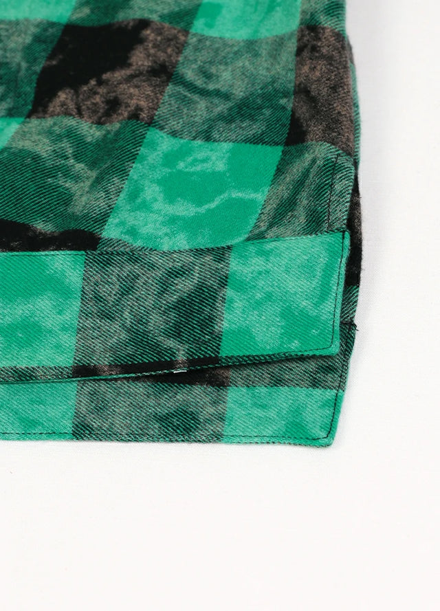 Close-up of the hem on a women's green black long sleeve plaid shirt