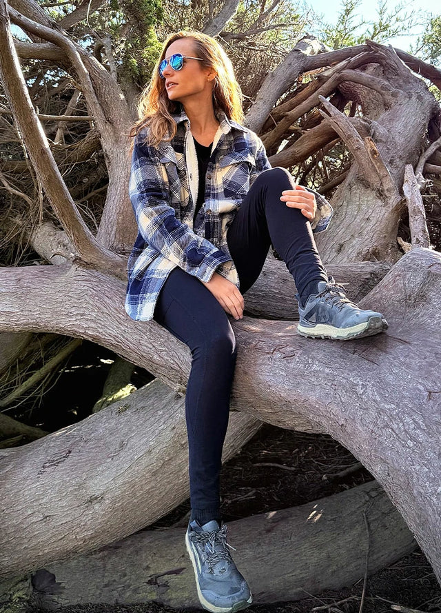 Women in a black and blue sherpa lined fleece plaid shacket with button up