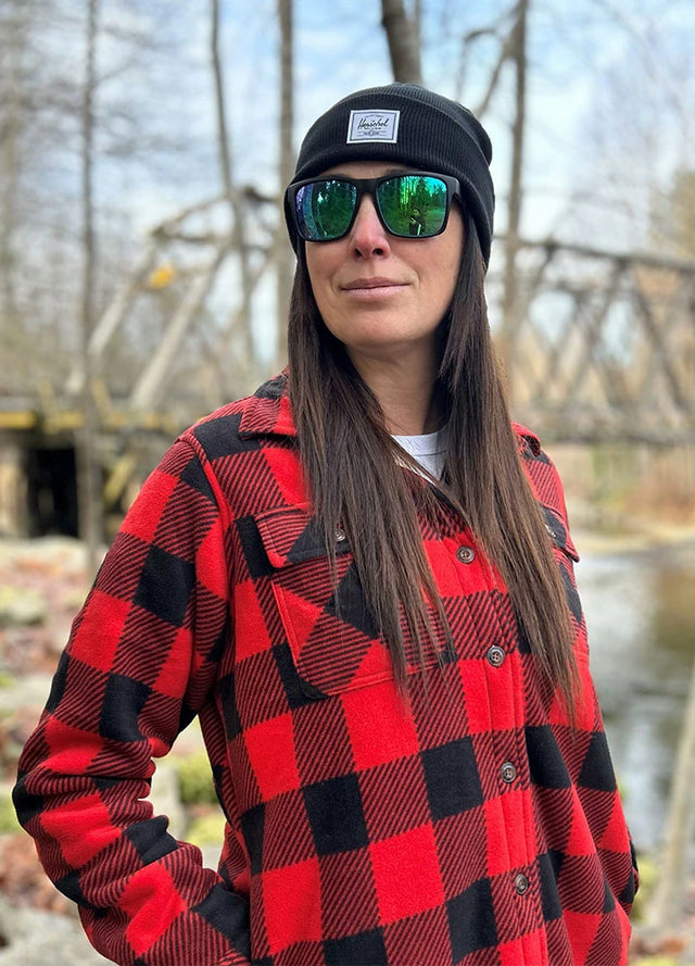 Side view of women in a sherpa-lined black and red fleece shacket