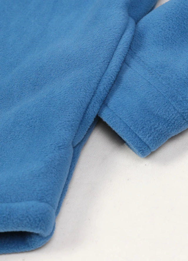 Close-up of a womens sherpa lined royal blue fleece shacket hand pocket