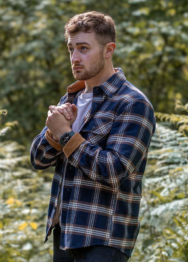 Front view of a man wearing a navy coffee men's durable flannel cotton shirt with his hands clasped