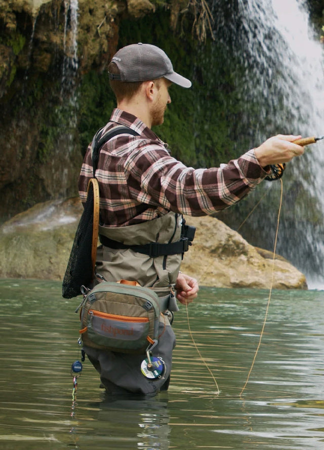 Back view of a man wearing a pink coffee midweight flannel cotton shirt standing in the water
