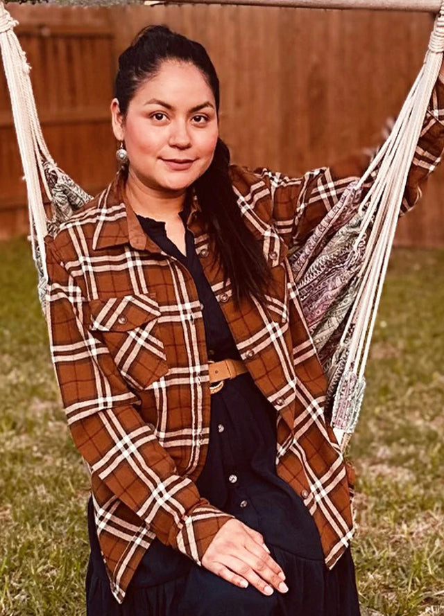 Women wearing a button down brown plaid flannel shirt