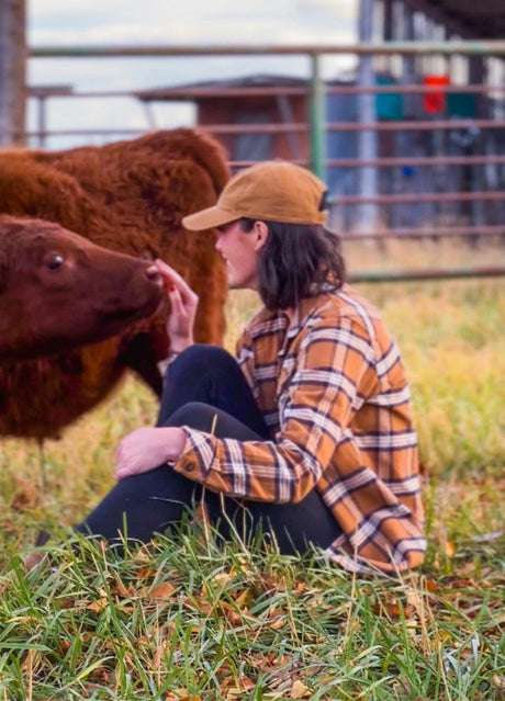 Women wearing a button down brown plaid flannel shirt