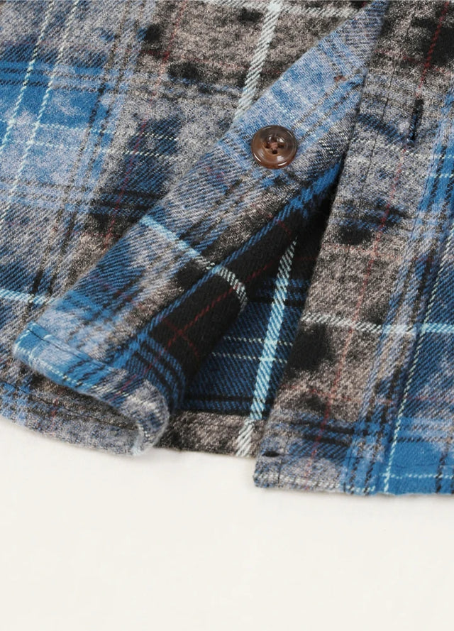 Close-up of the hem of the blue and black men's acid washed flannel shirt