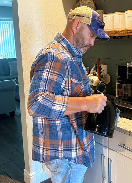 Side view of a man in a blue orange men's warm long sleeve western flannel shirt