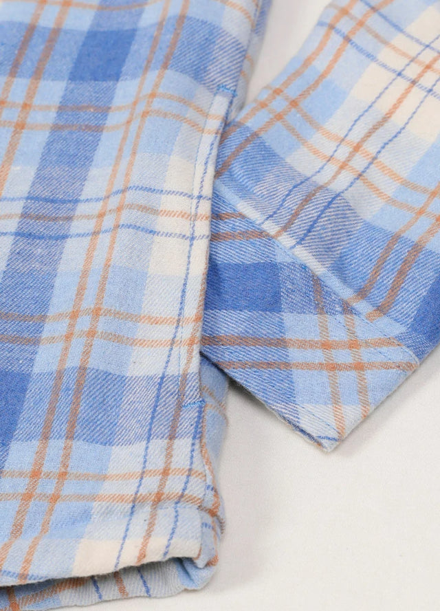 Close-up of the pocket on a women's long-sleeve blue khaki flannel shacket