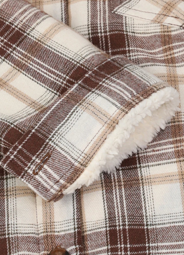 Close-up of the cuffs on a women's long-sleeve chocolate cream flannel jacket for winter