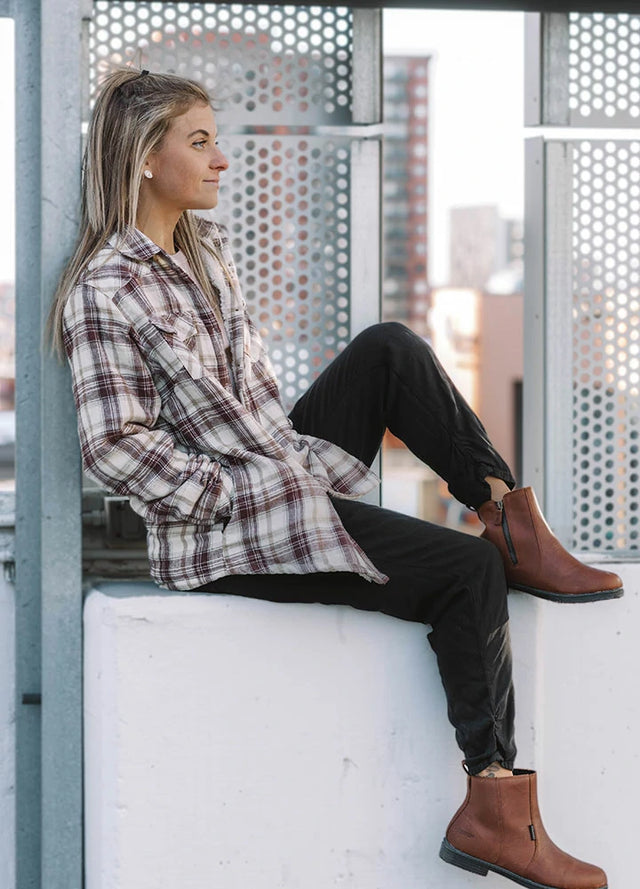 Side view of a woman in a chocolate cream flannel shacket with sherpa lined