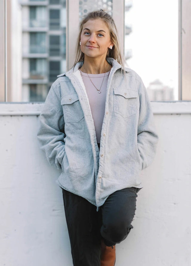 Women in a winter warm solid gray button down flannel jacket