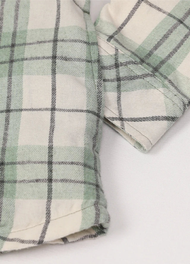 Close-up of the hand pocket on a women's sherpa-lined green flannel shirt jacket