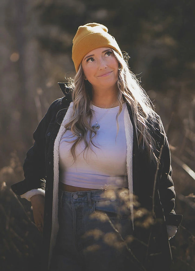 Women in a solid black button down flannel shirt jacket with sherpa lining