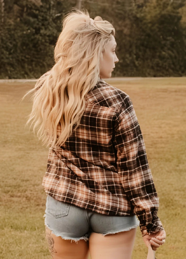 Women in a black khaki button down flannel shirt jacket with sherpa lining