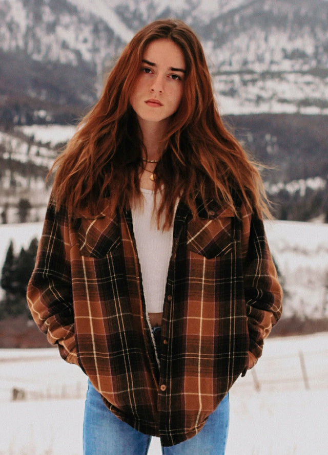 Women in a chocolate button down flannel shirt jacket with sherpa lining