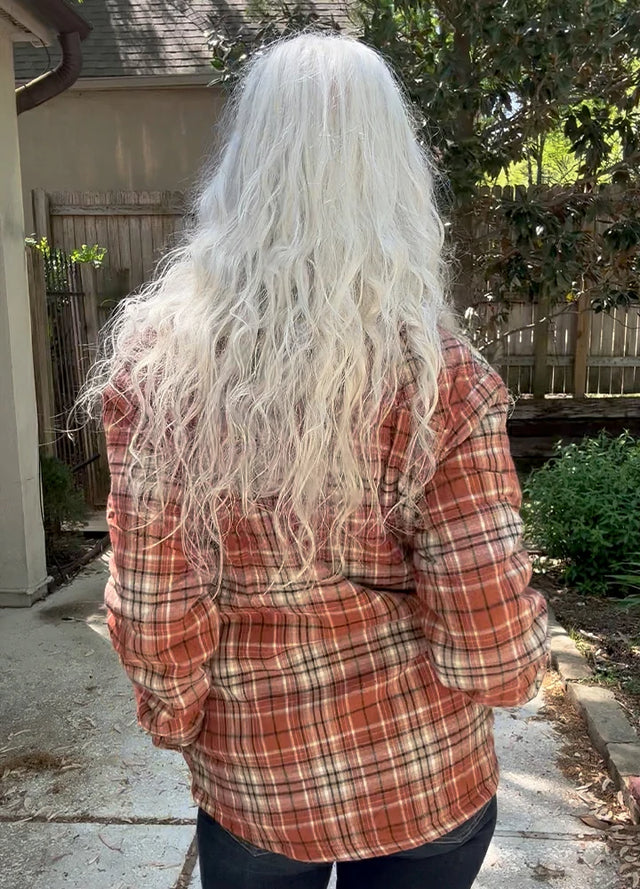 Back view of Women in a brown plaid long-sleeves flannel jacket with sherpa-lined