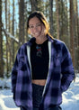 Women in a purple and black button down flannel shirt jacket with sherpa lining