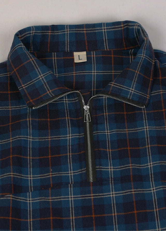 Close-up of the neckline of a blue and navy women's casual quarter zip flannel shirt