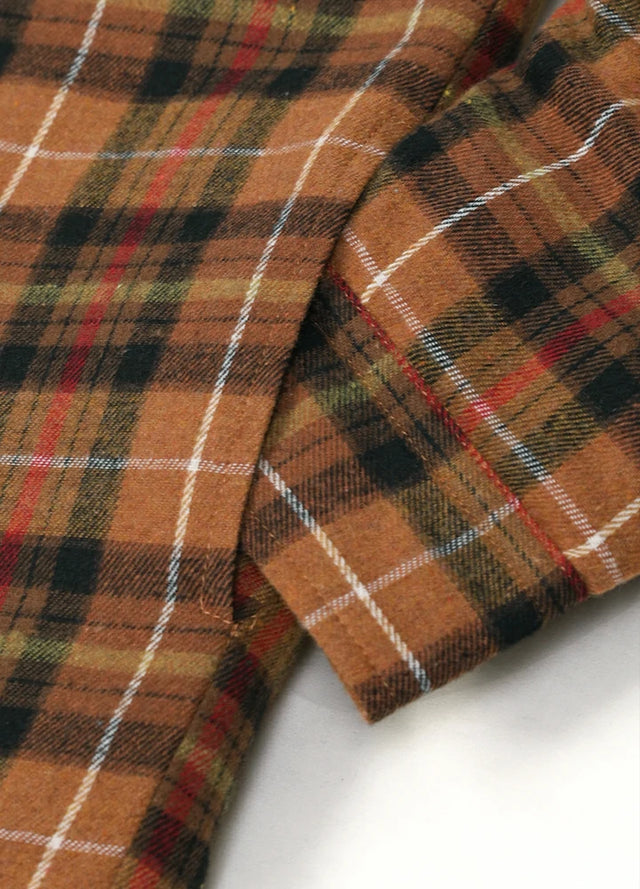 Close-up of the seam pocket of coffee and red men's quilted lined brushed flannel jacket