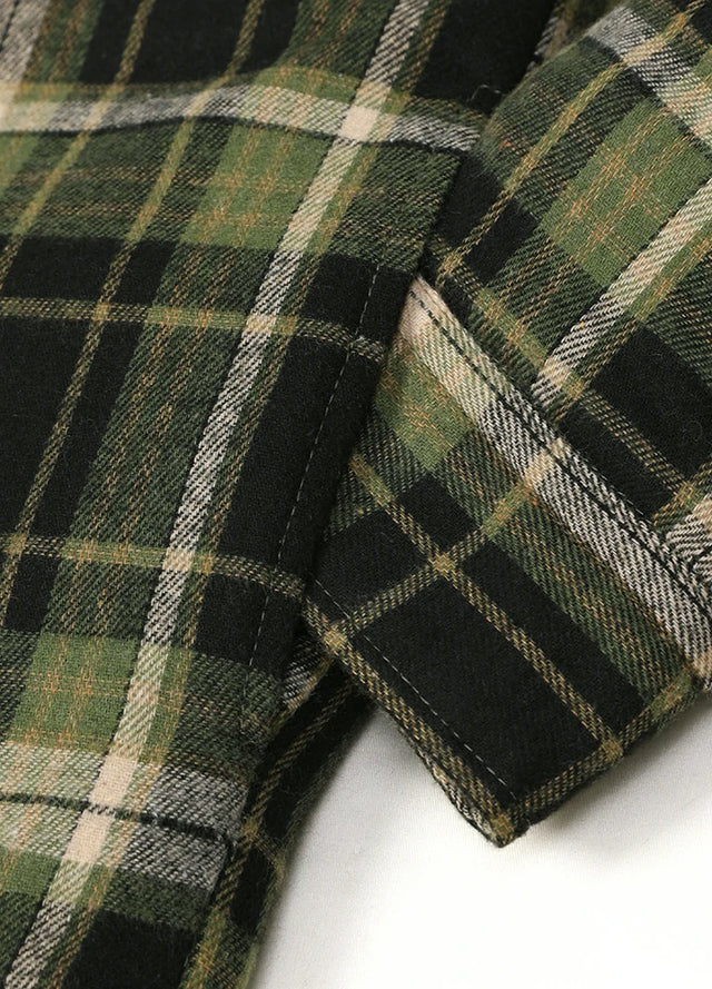 Close-up of the seam pocket of green and black men's quilted lined brushed flannel jacket
