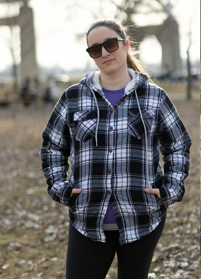 Women in a black white sherpa lined plaid flannel jacket with hood