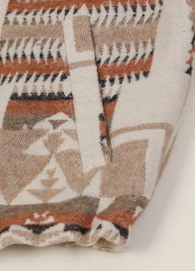 Close-up of the hand pocket on a women's khaki brown cropped aztec shirt jacket