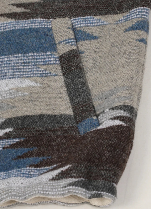 Close-up of the hand pocket on a women's gray blue cropped aztec shirt jacket